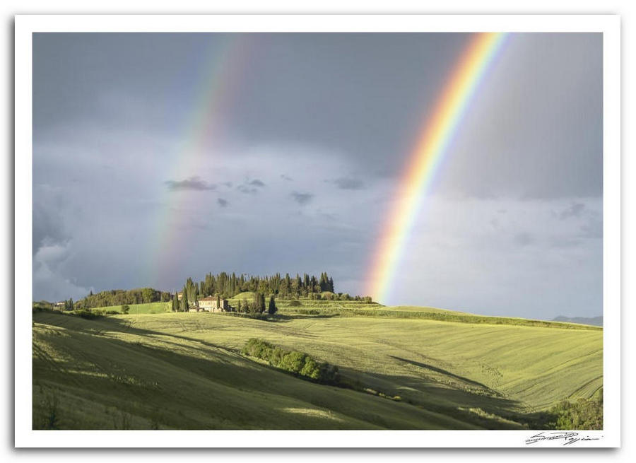Fotografia artistica di Silvano Poggiani raffigurante il paesaggio della campagna toscana vicino Cosona, Siena. Paesaggio con doppio arcobaleno e casolare in lontananza.