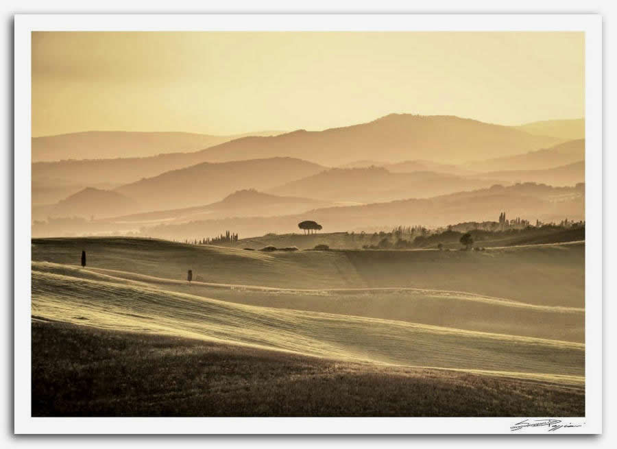 Fotografia artistica di Silvano Poggiani raffigurante il paesaggio toscano vicino Montalcino con sequenza di colline al tramonto con sfumature dorate