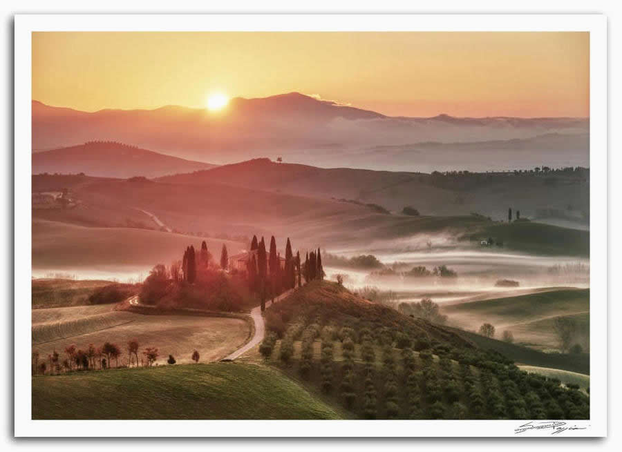 Fotografia artistica di Silvano Poggiani raffigurante il paesaggio della campagna toscana vicino San Quirico d'Orcia. Alba sulle colline con nebbia e cipressi, veduta panoramica del podere Belvedere nella val d’Orcia.