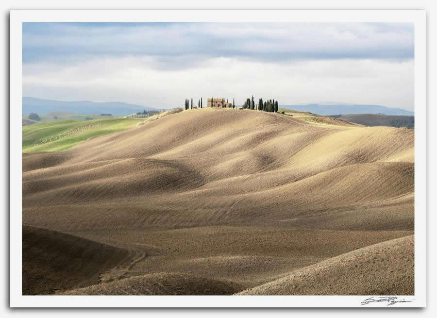 Fotografia artistica di Silvano Poggiani raffigurante il paesaggio della campagna toscana vicino Siena. Paesaggio con colline ondulate e casolare sulla cima circondata da cipressi, tipico scenario delle crete senesi.